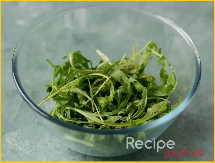 В салатник выкладываем рукколу, её можно порвать руками если крупная, или использовать целиком, если мелкая.