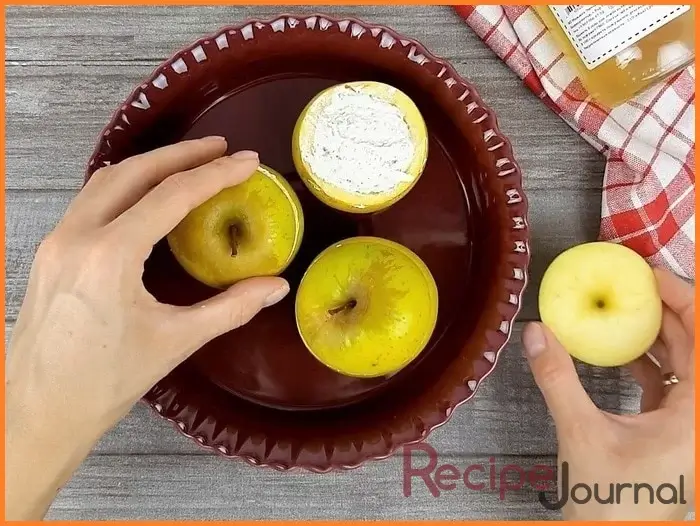 Выкладываем нафаршированные яблоки в форму для запекания и накрываем срезанными верхушками. Отправляем яблоки в духовку при 190 <sup>о</sup> на полчаса.