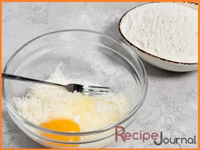Вобьем в миску подходящего размера яйцо, добавим сыр, соль и молоко, хорошо перемешаем и добавим муку. Замешаем тесто.