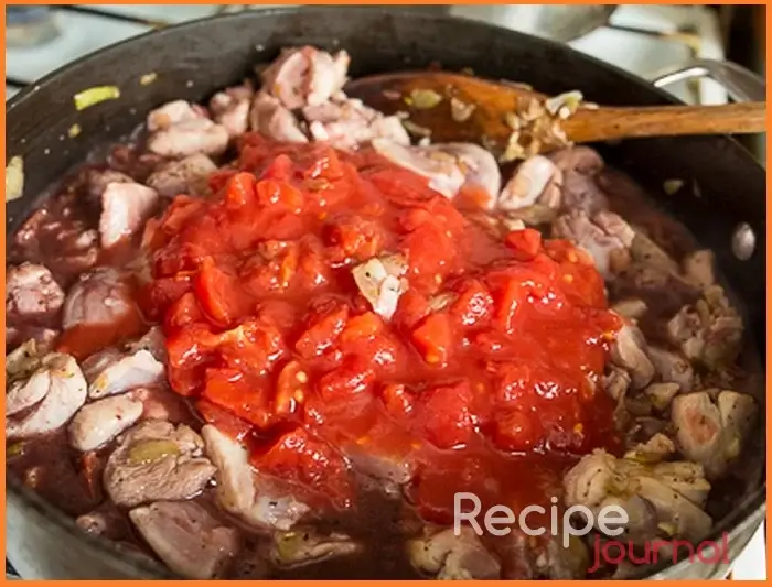 Когда мясо посветлеет, разминаем и добавляем томаты, вино, солим по вкусу. Хорошенько перемешиваем, убавляем огонь до слабого, накрываем крышкой и тушим около 20 минут.