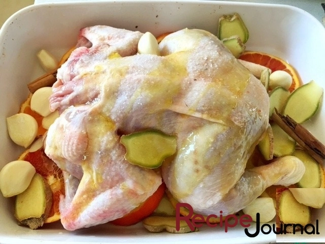 На курицу кладем чеснок с имбирем, поливаем оливковым маслом.