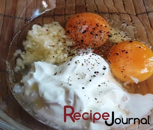 Яйца, сметану и раздавленный чеснок взбить, добавить специи и перемешать.