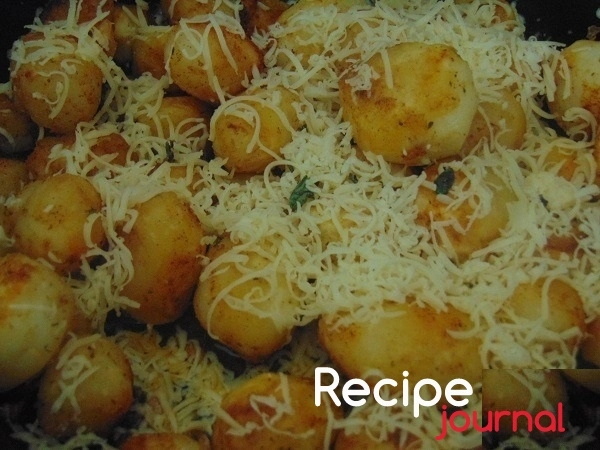 Посыпать картофель тертым сыром. Выключить духовку и поставить в неё картофель на 15 минут.
