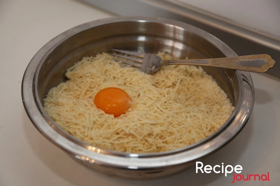 Сыр натираем на крупной терке и добавляем яйцо.