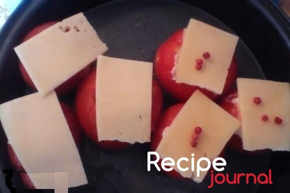 Начинить помидоры и выложить на противень. Накрыть листочками сыра и отправить в духовку.Запекать при 200<sup>о</sup> 15 минут. Помидоры, запеченные с мидиями готовы!
