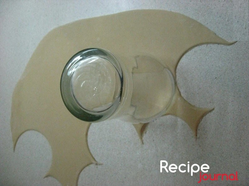 Вот и наше тесто отдохнуло. Раскатываем в тонкий пласт и, при помощи стакана или другого приспособления, вырезаем круги.
