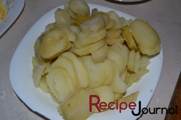 Отваренный заранее картофель, очистить и нарезать пластинами.