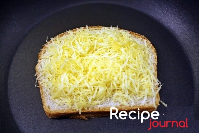 Разогреваем сковороду,  кладем хлеб маслом вниз. На хлеб накладываем натертый сыр и накрываем другим ломтиком хлеба маслом вверх.