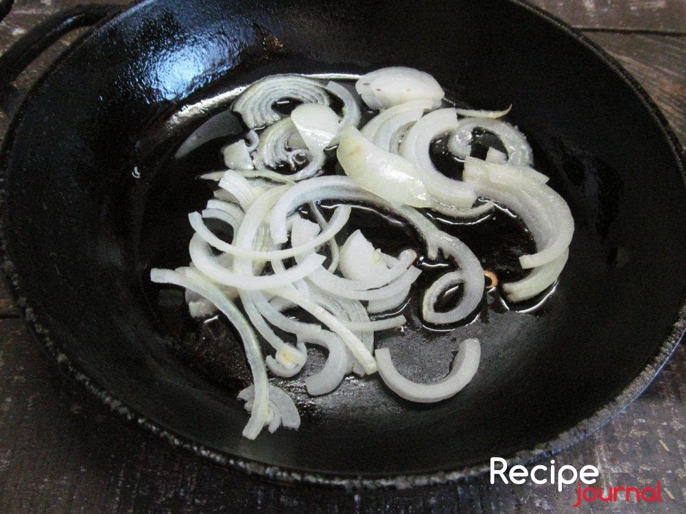 В глубокой сковороде разогреть растительное масло и пассеровать нарезанный полукольцами лук.
