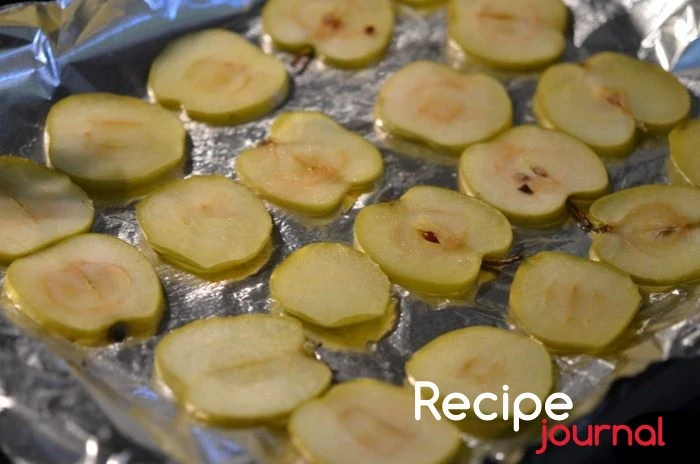 Противень застелить пекарской бумагой и разложить на нем при помощи щипцов яблоки. Отправить в разогретую духовку на 15 минут, затем переключить температуру на 120<sup>о</sup>.