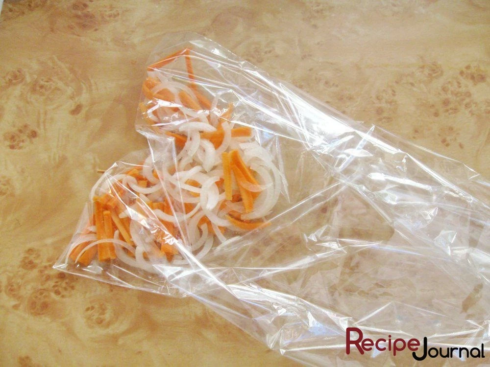 Лук нарезаем полукольцами, а морковь соломкой. Складываем в пакет для запекания и сбрызгиваем растительным маслом.