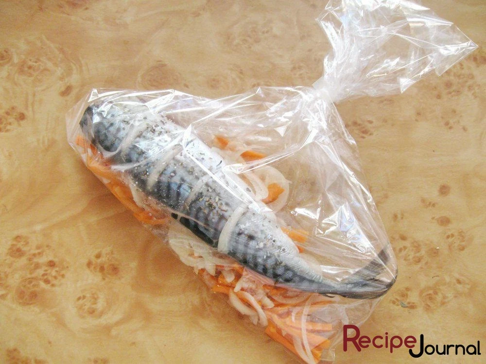 Укладываем рыбу на овощи, закрепляем края пакета.