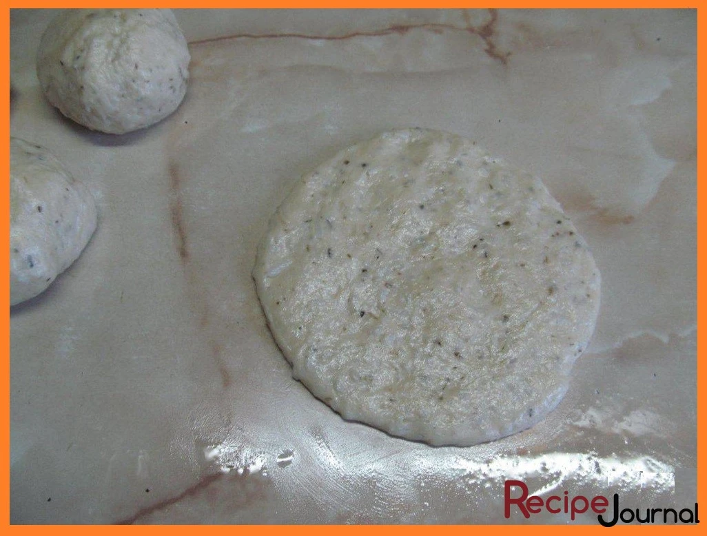 Когда тесто увеличилось в объеме примерно вдвое, делим его на 6 частей. Каждую раскатываем в тонкую лепешку.