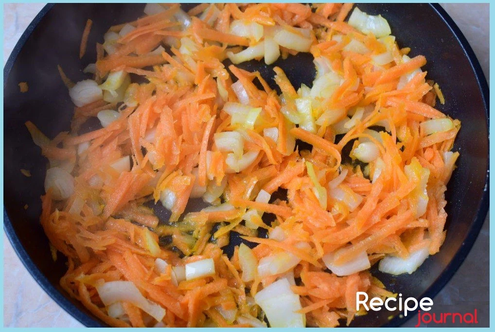 Убираем рыбу со сковороды, добавляем немного масла, порезанный кубиком лук и натертую на крупной терке морковь. Пассеруем овощи на среднем огне до прозрачности лука.
