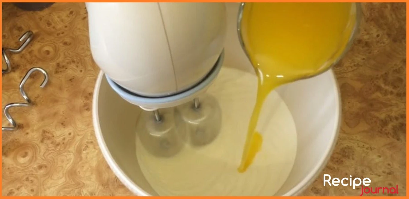 Желтки растираем с сахаром до бела, добавляем воду не переставая взбивать, затем вводим охлажденное растопленное сливочное масло, так же продолжая взбивать.