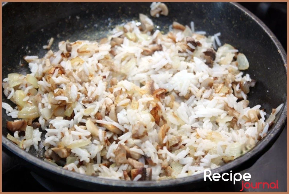 Добавляем на сковороду отваренный рис, солим, перчим, перемешиваем.