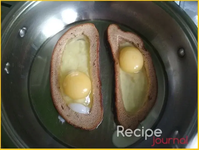 Когда корочки подрумянились, вбиваем в каждую по яйцу, солим и перчим по вкусу. Если яйцо вытекает, слегка прижимаем хлеб к сковороде.